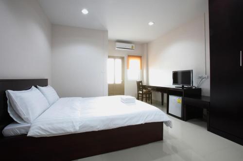 a bedroom with a bed and a desk with a computer at Garden Hill Hotel in Trang