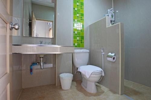 a bathroom with a sink and a toilet at Garden Hill Hotel in Trang