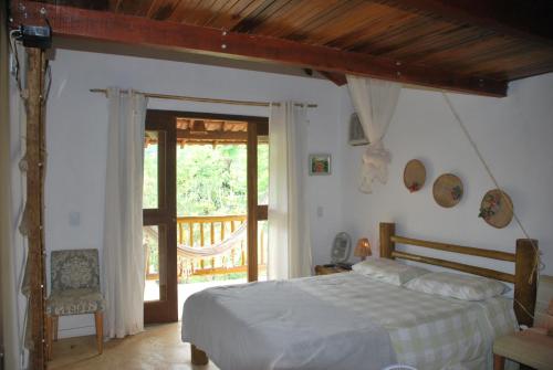 1 dormitorio con 1 cama y puerta corredera de cristal en Casa do Capão, en Vale do Capao