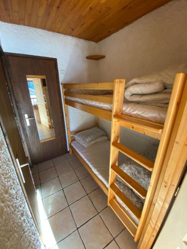 a room with two bunk beds in a cabin at Champagny Ski Studio - Le Dahut in Champagny-en-Vanoise
