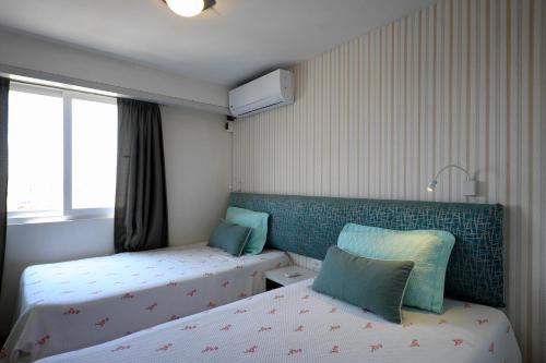 Habitación pequeña con 2 camas y ventana en Guernica Apartments, en Lima