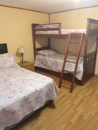 1 dormitorio con 2 literas y escalera en Casa Sol y Luna en Ushuaia