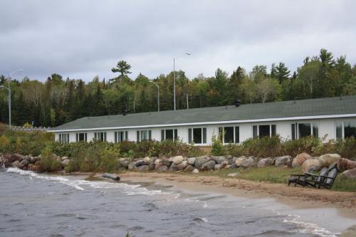 a building on the shore of a body of water at Carolyn Beach Inn in Thessalon
