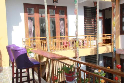 einen Balkon mit 2 Stühlen und einem Holzgeländer in der Unterkunft Hoi An Golden Horse Villa in Hoi An