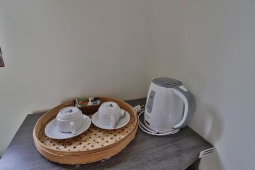 a table with a coffee maker and two cups on it at Arya Resort Nusa Penida in Nusa Penida
