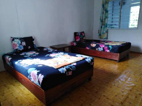 a bedroom with two beds and a window at AA Homestay in Mulu