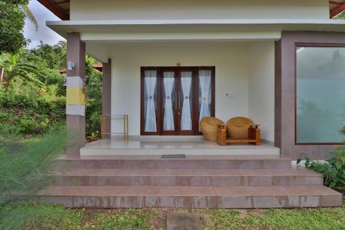 a house with stairs leading to a front door at Arya Resort Nusa Penida in Nusa Penida