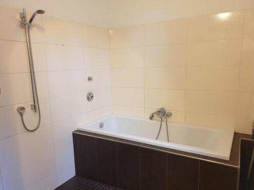uma banheira na casa de banho com um chuveiro em Pension I em Berlim