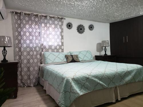 a bedroom with a bed with a green comforter at Hill Retreat - Kingston in Kingston