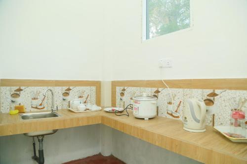 a kitchen with a counter with a sink and appliances at Raviru Guest Mirissa in Mirissa