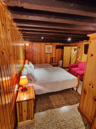 a bedroom with a large bed and a chair at La casa del pescatore: a lovely escape in Venice!! in Venice