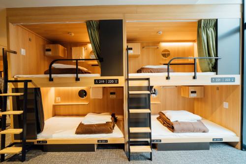 a room with bunk beds in a hostel at WeBase Hiroshima in Hiroshima