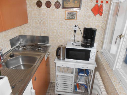 a small kitchen with a microwave and a sink at Appartment Kieper in Clarens