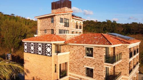 a brick building with a tower on top of it at 墾丁南灣Relaxury旅浪沙戀民宿 in Nanwan