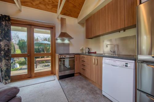a kitchen with wooden cabinets and white appliances at Willowbrook Country Apartments in Arrowtown