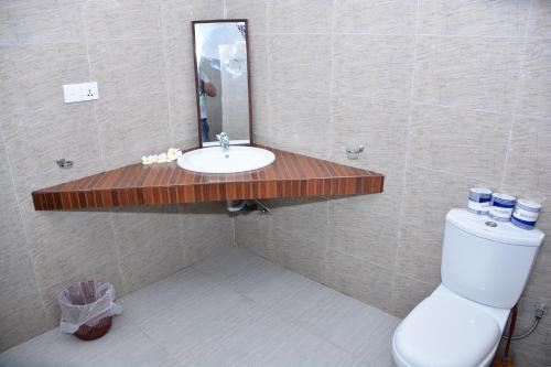 a bathroom with a sink and a toilet and a mirror at Little Sunshine Guest House & Restaurant in Tangalle