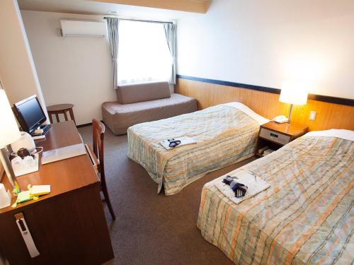 a hotel room with two beds and a desk at Hotel Asyl Nara Annex in Nara