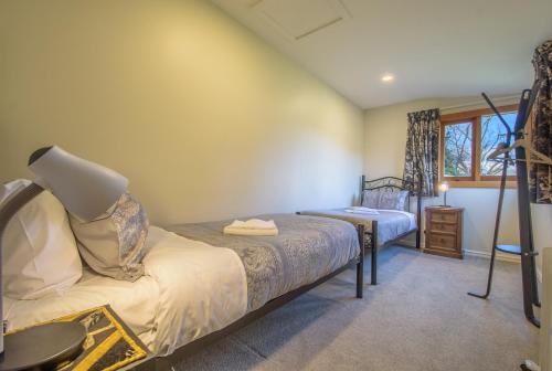 a bedroom with two beds and a window at Willowbrook Country Apartments in Arrowtown