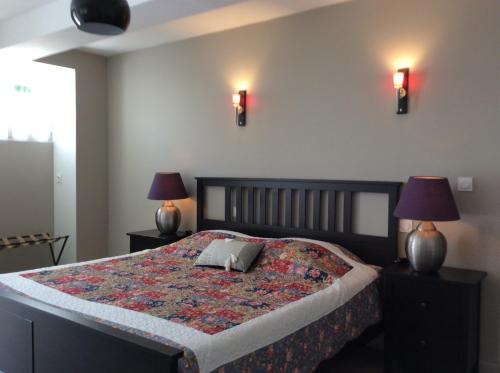 una camera da letto con un letto con due lampade sopra di LE MOULIN DE BOULÈDE a Monflanquin