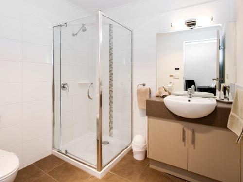 a bathroom with a glass shower and a sink at Ballarat Central City Motor Inn in Ballarat