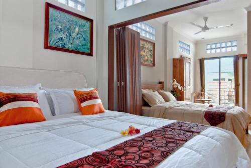 a bedroom with two beds and a large window at Kuta EcoStay in Kuta