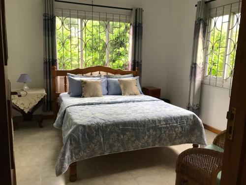 a bedroom with a large bed and a window at Tropical Garden Self Catering in Victoria