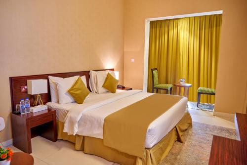 Cette chambre comprend un grand lit et une fenêtre. dans l'établissement Grand Square Hotel, à Dubaï