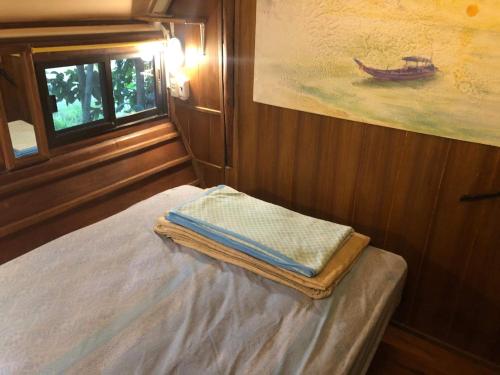 a room with a bed and a painting of a boat at Good Life Dacha Wellness Homestay in Pai