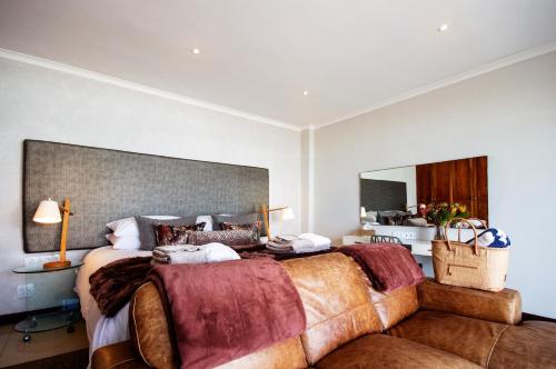 a bedroom with a large bed and a large mirror at Beach Villa Wilderness in Wilderness
