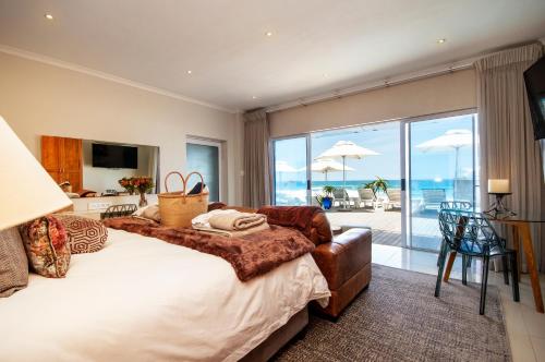 a bedroom with a bed and a view of the ocean at Beach Villa Wilderness in Wilderness
