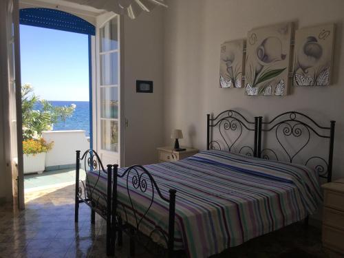 een slaapkamer met een bed en uitzicht op de oceaan bij Casa Direttamente sul mare in Marina di Mancaversa