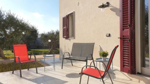 three chairs and a table on a patio at Tra gli ulivi in Putignano