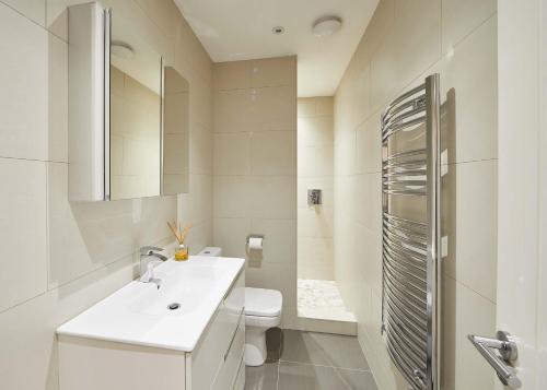 a white bathroom with a sink and a toilet at Host & Stay - Lowcross Cottage in Guisborough