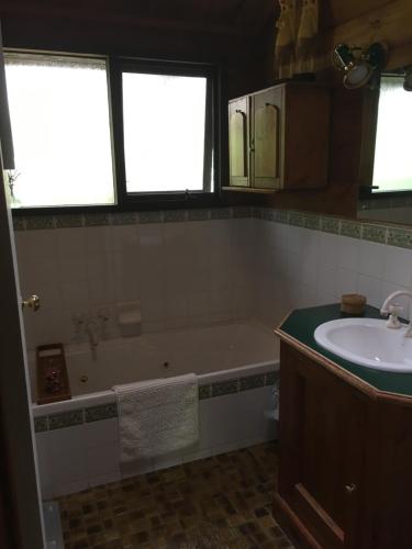 a bathroom with a tub and a sink at Hilltop in Stirling