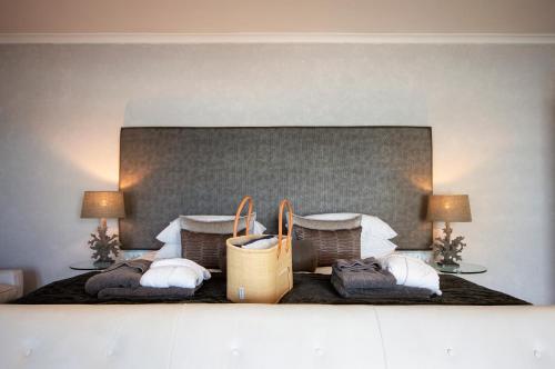 a hotel room with a bed with towels and bags at Beach Villa Wilderness in Wilderness