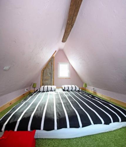 a bedroom with a large bed in a attic at Dziewięćsił-domek w górach in Duszniki Zdrój