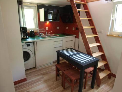 a kitchen with a staircase and a table in a room at Dziewięćsił-domek w górach in Duszniki Zdrój