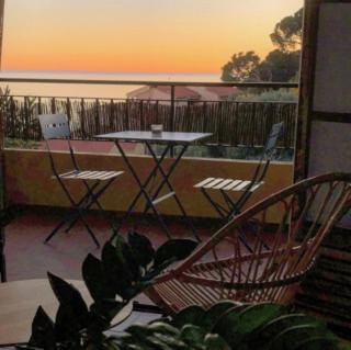 un patio avec une table et des chaises sur un balcon dans l'établissement Magnifique T1 Bis Vue mer Route des sanguinaires Ajaccio, à Ajaccio