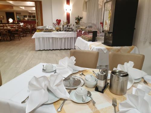 Waldhotel Rennsteighöhe في فراونوالد: طاولة عليها أغطية طاولات بيضاء