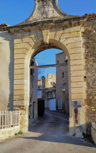 an archway in an old building with a street at LES JARRES BLEUES in Grillon