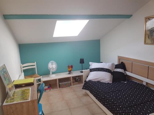 1 dormitorio con cama y pared azul en Domaine de Mélody, en Moriani Plage
