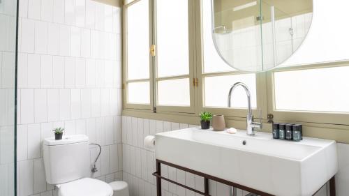 a bathroom with a sink and a toilet and a mirror at Ruby in Tel Aviv