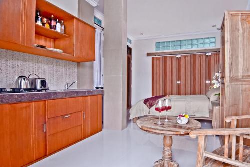 a kitchen with a table with a glass of wine at Kuta EcoStay in Kuta