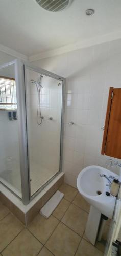 a bathroom with a shower and a sink at Acacia Westdene B&B in Bloemfontein