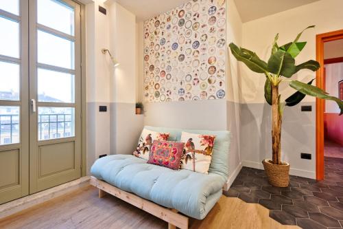 Pokój z niebieską kanapą i doniczką w obiekcie La casa del Mercato - Design Apartment w Turynie