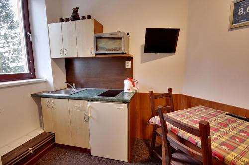 a small kitchen with a sink and a microwave at Apartmany Kadleců in Volary