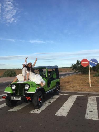 two people are sitting on the back of a jeep at Lang Chai Guesthouse in Mui Ne