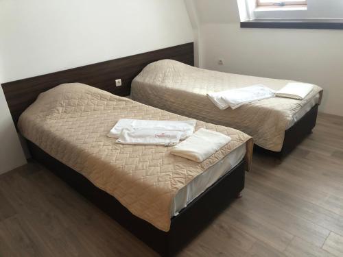 2 Betten in einem Hotelzimmer mit Handtüchern darauf in der Unterkunft Number 9 in Kumanovo