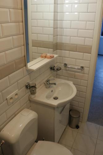 a white bathroom with a toilet and a sink at B&B Den Boskant in Zandbergen