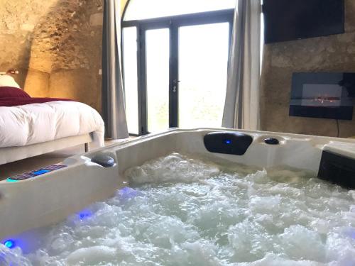 Una bañera llena de agua en una habitación. en Paradise Love In Provence - loft en pierres - spa privatif, en Reillanne